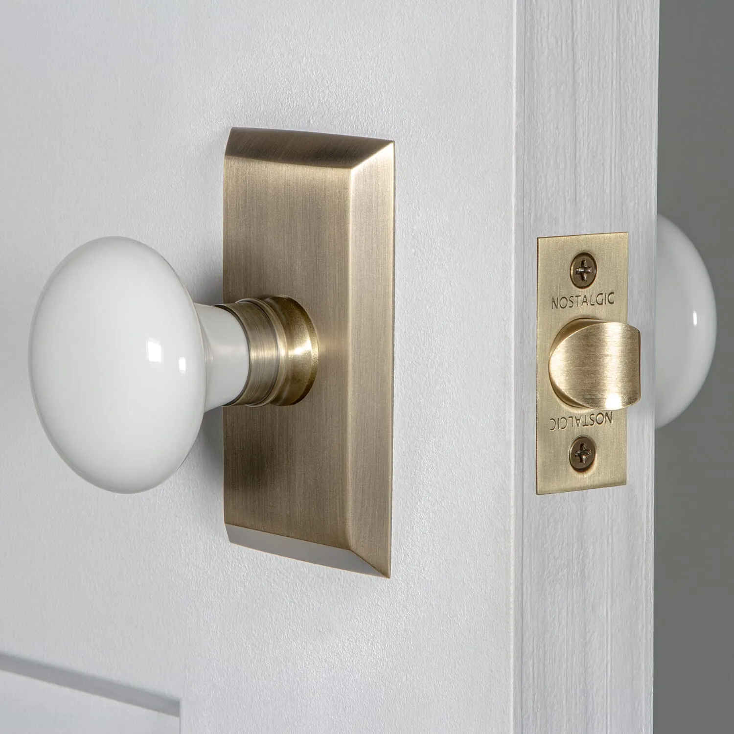 Studio Short Plate with White Porcelain Knob in Antique Brass